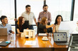 © AntonioDiaz - Group of businesspeople and architects dressed casual and examining some building plans together