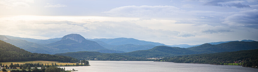 Canvas Print - Panoramic view of a lake surrounded by lush green hills