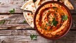 Roasted red pepper hummus with pita bread on wooden background. 