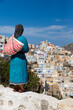 Statue of a greek woman in a traditional outfit looking over Olympos, Karpathos, Greece.
