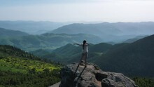 A Tourist Girl On Top Of A Mountain, Raising Her Hands, Rejoices And Dances In Front Of A Wonderful View. You Are Free And Feel Freedom, Inspiration For New Achievements. The Whole World Is In Your