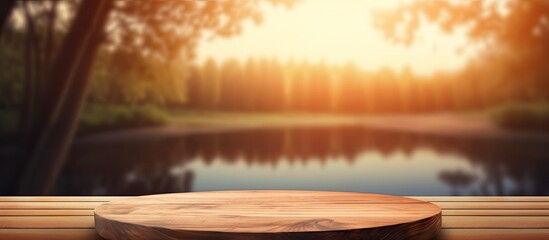 Sticker - A wooden table is in the foreground with a serene lake in the background, reflecting the morning sunlight. The natural landscape includes grassy areas leading to the body of water