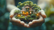 LIFESTYLE IMAGE- model house with trees and greenery in woman's hands isolated on blur background