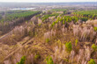 Rozległy obbszar leśny poktryty mieszanym lasem. Jest zima, liściaste drzewa pozbawione są liści. Między nimi widać zieleń drzew iglastych. Zdjęcie z drona.