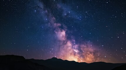 Wall Mural - A breathtaking view of the Milky Way stretching above silhouetted mountains under the dark night sky