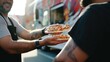 © Major - Close-up of hands sharing a slice of pizza with multiple toppings, symbolizing friendship and the culture of street food