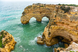 Fototapeta  - Natural caves and beach, Algarve Portugal. Rock cliff arches of Seven Hanging Valleys and turquoise sea water on coast of Portugal in Algarve region