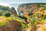 Fototapeta  - Natural caves and beach, Algarve Portugal. Rock cliff arches of Seven Hanging Valleys and turquoise sea water on coast of Portugal in Algarve region