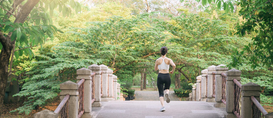 Wall Mural - asian woman jogger, running over the bridge in public park.