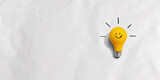 Fototapeta Miasto - Yellow light bulb with happy face - flat lay