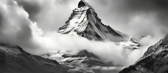 Canvas Print - Majestic Mountain Peak Shrouded in Ethereal Clouds at Sunset