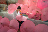 Fototapeta Miasta - Thai woman people making pink umbrellas. Decoration. People lifestyle