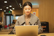 © zhouyilu - Young Businesswoman Focused on Laptop in Caf?