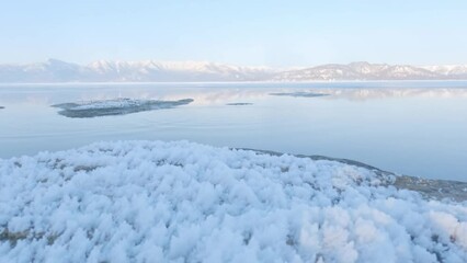 Wall Mural - ripples on calm lake surface in frozen winter landscape, hokkaido, japan