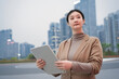 © 昊 周 - Confident Businesswoman Using Tablet in Urban Setting