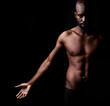 © Mikolette Moller/peopleimages.com - Black man, shadow and fitness with muscular body for exercise or workout on a dark studio background. Young African male person or strong bodybuilder with masculine or muscle figure on mockup space