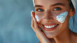 Close-up of a smiling woman applying facial cream, hyperrealistic digital illustration, blue background, skincare and beauty concept. Generative AI