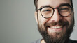 © VK Studio - Close-up of a bearded man smiling cheerfully with glasses.