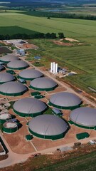 Wall Mural - Modern agribusiness plant for green fuel production. Futuristic biogas complex locating in vast fields. Aerial perspective. Vertical video
