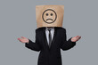 © millaf - Standing business person paper bag head with sad emoticon on gray background