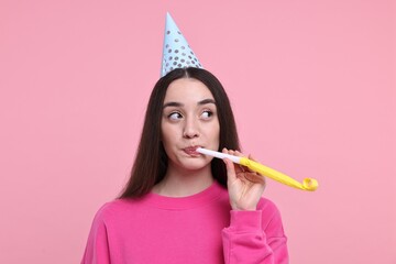 Poster - Woman in party hat with blower on pink background