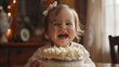 happy white english girl female toddler giggling and laughing celebrating her birthday with birthday cake