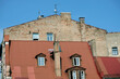 Building wall in bad condition above red metal roof in old town of Riga front view