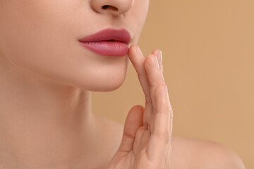 Wall Mural - Young woman with beautiful full lips on beige background, closeup