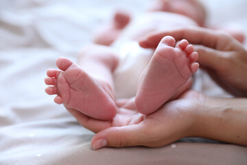 Sticker - Mother and her newborn baby on bed, closeup