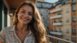 Fröhliche junge Frau mit natürlichem Make-up lächelt auf Stadtbalkon