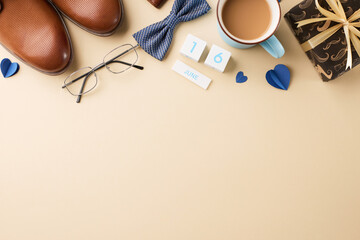 Defining fatherly Elegance: father's day selection. Top view shot of brown shoes, blue tie, eyeglasses, calendar blocks, blue hearts, cup of coffee and gift on beige background with space for messages