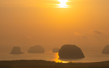 .Imagine a beautiful bright yellow sky at sunrise..stunning view of the beautiful Phang Nga Bay. .beautiful yellow sunrise at Samet Nangshe landmark of Phang Nga Thailand. .island background. ..