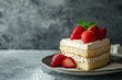 Tres leches cake with strawberry garnish and whipped cream on a plate