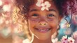 Mała dziewczynka uśmiecha się wiosennie, mając różowy kwiat wetknięty we włosach. Jej radosna mina wyraża szczęście i radość.
