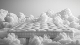 Fototapeta Tulipany - A mattress in the middle of a cloud filled sky.
