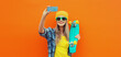 © rohappy - Summer portrait of happy smiling blonde young woman taking selfie with smartphone and skateboard