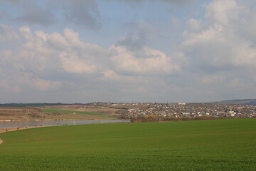 Wall Mural - A field with a town in the distance