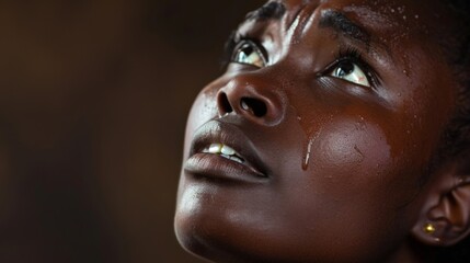 Touched by His Grace. Beautiful young black woman looking up with tears in her eyes.