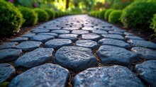 Close-up view of smooth cobblestones on a garden path surrounded by lush greenery and flowers.