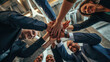 © MP Studio - Low-angle view of a diverse group of professionals engaged in a team-building exercise, where they join their hands together in a show of unity and cooperation.