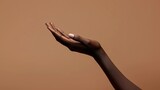 Fototapeta Londyn - Close-up of african american woman hand with palm facing upwards isolated on brown background.