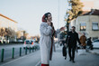 © qunica.com - A young businessman laden with shopping bags confronting his girlfriend who is engaged in a phone call. The couple appears to be in the middle of a conversation on a city street.