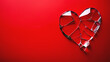 Red glass broken heart. Shiny heart with cracks made of bright red glass isolated on a red background. Relationship issues concept, Valentine's Day theme.