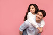 © Home-stock - Happy european young father carrying his daughter piggyback and looking at free space, posing over pink studio background, place for advertisement