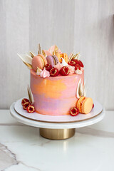 Wall Mural - Pink cake decorated with fresh raspberries, chocolate petals, macaroons and meringues