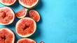 Sliced grapefruits arranged on a blue background with space on the right.