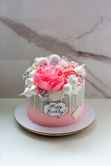 Wall Mural - Beautiful and elegant grey and pink cake decorated with melted white chocolate, macaroons, edible peony flower and meringue kisses