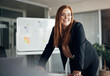 © Flamingo Images - Young executive female with beautiful long red hair laughing while giving an office whiteboard presentation