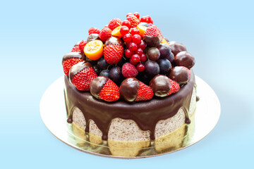 Wall Mural - Cake decorated with strawberry dipped into melted chocolate, raspberry, blueberry and red currant. Isolated on plain background