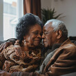 Mature elderly black couple sitting on couch looking at each other